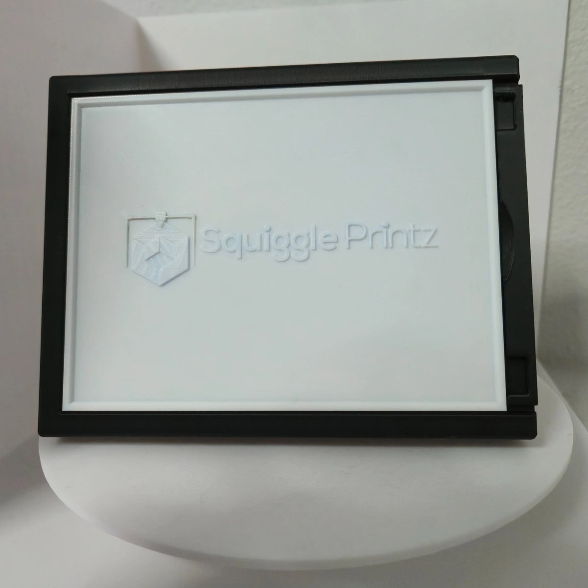 Custom lithophane in its black display frame with the light off, showing the textured panel