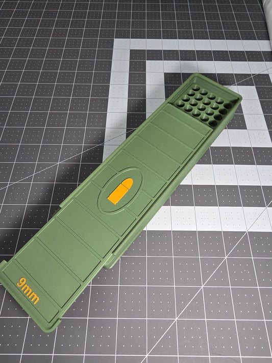Green 3D-printed 9mm 100-round ammo storage box with orange accents on a grid mat.
