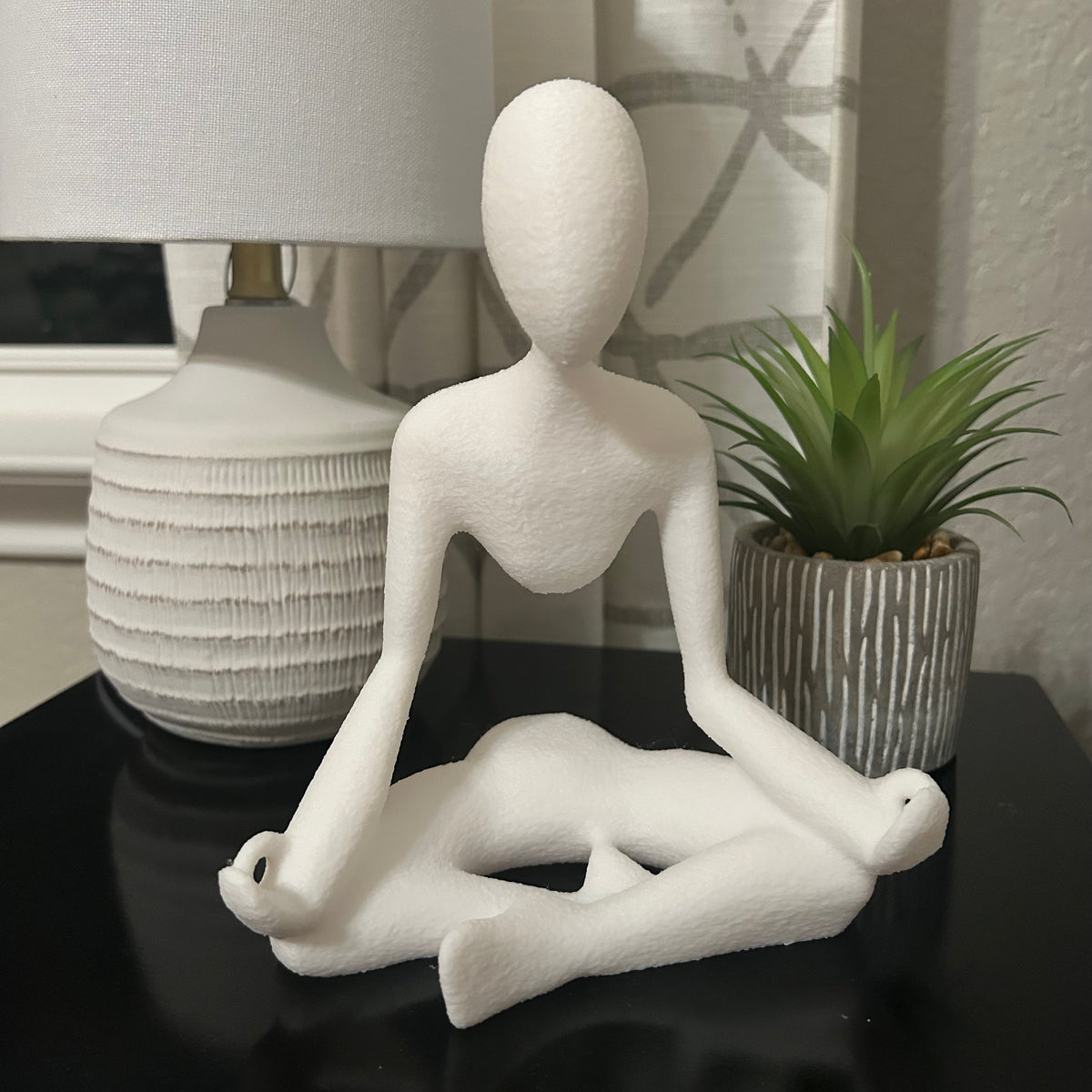 Medito sculpture shown from the side revealing the support.