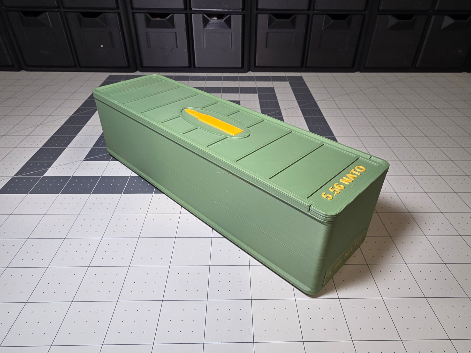Angled view of closed 5.56 NATO 100-round ammo storage case with cartridge icon and 5.56 NATO text on the lid, 3D printed by SquigglePrintz