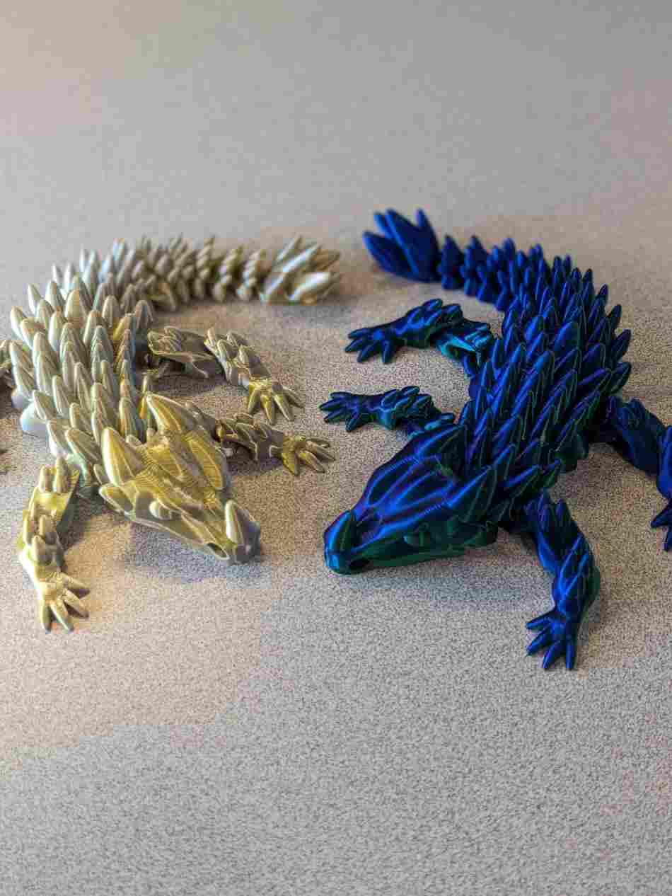 Small baby dragon articulated print-in-place figure, 3D printed. Design by Bearded Printer.