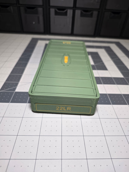 Closed olive green .22LR ammo storage box front view with 22LR label on the end face and cartridge icon on the sliding lid, 3D printed by SquigglePrintz