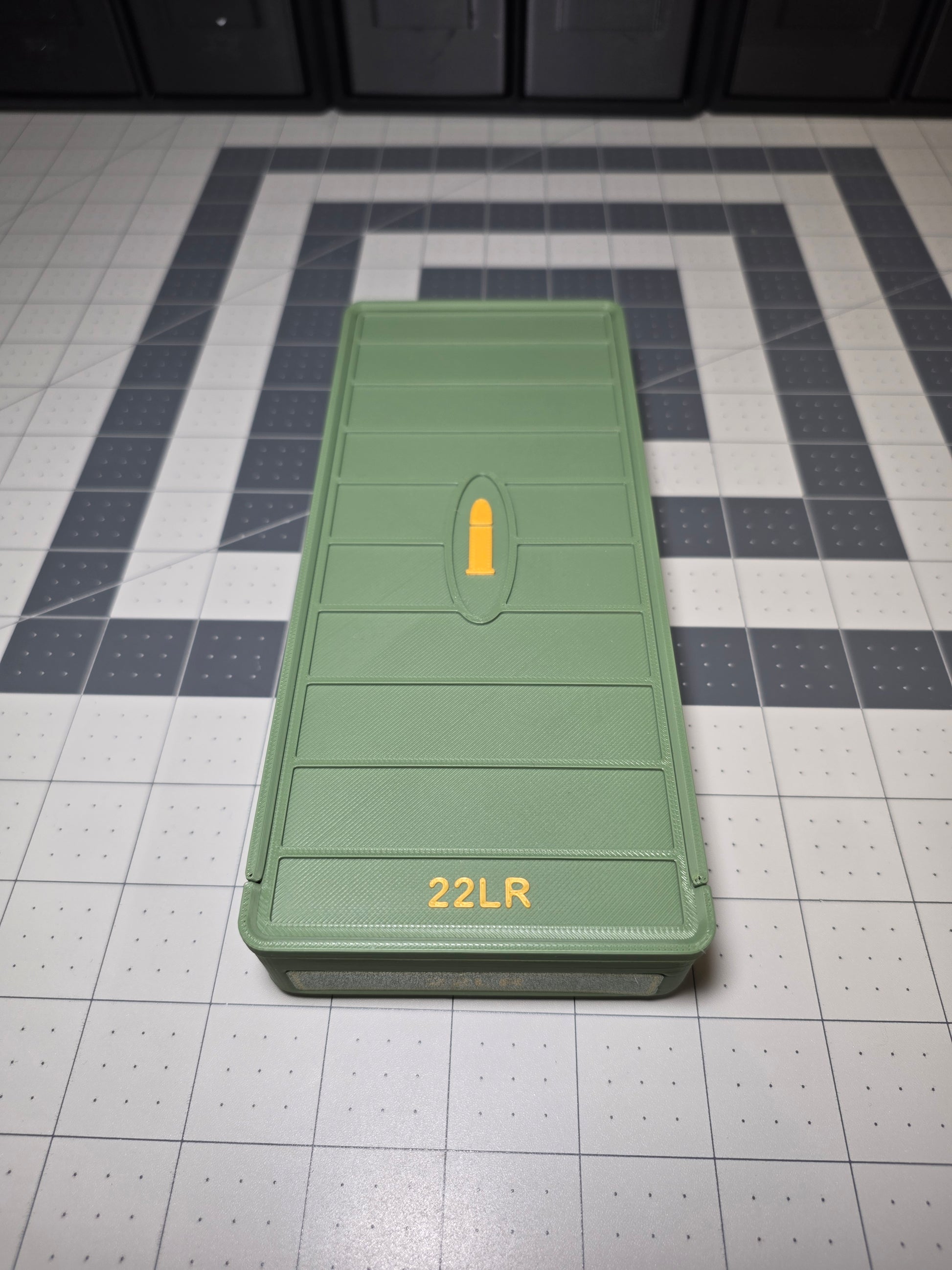 Olive green 3D printed .22LR ammo storage box closed with sliding lid, raised yellow cartridge icon and 22LR label, by SquigglePrintz