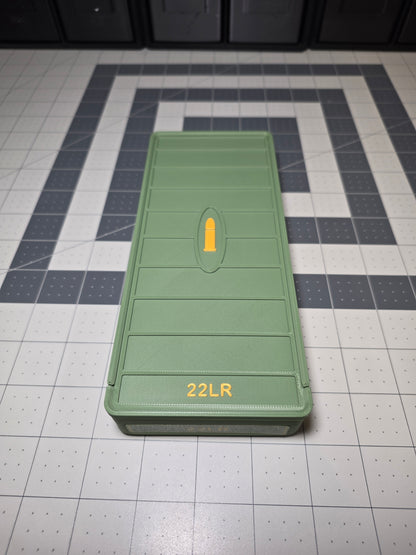 Olive green 3D printed .22LR ammo storage box closed with sliding lid, raised yellow cartridge icon and 22LR label, by SquigglePrintz